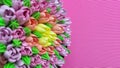 Multicolored cream tulips on a cake on a background of pink corrugated paper