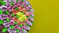 Multicolored cream tulips on a cake on a background of yellow corrugated paper