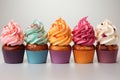 Multicolored cupcakes with buttercream on a light background