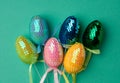 Multicolored decorative Easter eggs decorated with sequins on a green background Royalty Free Stock Photo