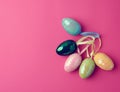 Multicolored decorative Easter eggs decorated with sequins on a pink background Royalty Free Stock Photo