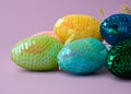 Multicolored decorative Easter eggs decorated with sequins on a purple background Royalty Free Stock Photo