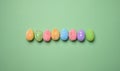 Multicolored decorative Easter eggs on green background, top view Royalty Free Stock Photo