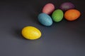 Multicolored decorative Easter eggs lie randomly on a dark background. Royalty Free Stock Photo