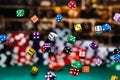 Multicolored dice Chips cascading in front of a background of stacked poker chips Royalty Free Stock Photo