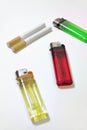 Multicolored disposable flint gas lighters and two cigarettes Royalty Free Stock Photo