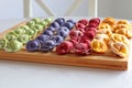 Multicolored dumplings are on a wooden board