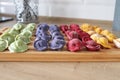 Multicolored dumplings are on a wooden board