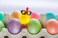 Multicolored easter eggs in a box with cute yellow chick. Copy space for your text Royalty Free Stock Photo