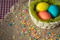 Multicolored eggs in easter festive basket on canvas napkin