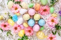 Multicolored eggs with flowers on a white background. Easter composition. Top view