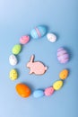 multicolored eggs and gingerbread in the form of a rabbit are scattered on a light blue background