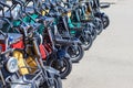 Multicolored electric bikes with headlights and baskets stand in a row on a sunny day. Walking rental for tourists. Royalty Free Stock Photo