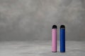 multicolored electronic cigarettes vape on dark background with smoke.