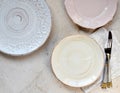 Multicolored empty ceramic plates on a marble background. Table setting. Shabby chic or retro style. Top view. Copy space. Mock up Royalty Free Stock Photo