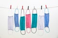 Multicolored fabric face masks drying on a rope held by Clothes pegs Royalty Free Stock Photo