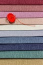 Multicolored fabric samples. Button with a needle and thread on the tissues with space for text Royalty Free Stock Photo