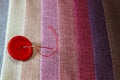 Multicolored fabric samples. Button with a needle and thread on the tissues with space for text Royalty Free Stock Photo