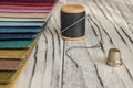 Multicolored fabric samples. A button with a needle and a thread on the tissues with space for text Royalty Free Stock Photo