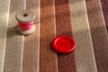 Multicolored fabric samples. A button with a needle and a thread on the tissues with space for text Royalty Free Stock Photo