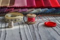 Multicolored fabric samples. A button with a needle and a thread on the tissues with space for text Royalty Free Stock Photo