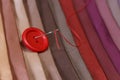 Multicolored fabric samples. Button with a needle and thread on the tissues with space for text Royalty Free Stock Photo