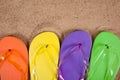 Multicolored flipflops in the sand Royalty Free Stock Photo
