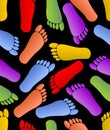 Multicolored footprints on black background, human traces in red, green, orange, purple and yellow colors, seamless Royalty Free Stock Photo