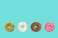 Multicolored frosted donuts with colorful sprinkles and hazels on blue background