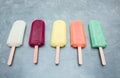 Multicolored frozen ice lolly on grey