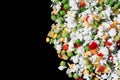 Multicolored frozen vegetables on the right side of the frame on a black background