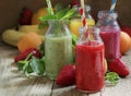 Multicolored fruit and berry smoothies, old wooden table, selective focus