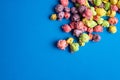 Multicolored fruit flavored popcorn on blue background. Candy coated popcorn