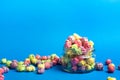 Multicolored fruit flavored popcorn in glass cups on blue background. Candy coated popcorn