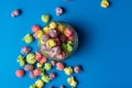 Multicolored fruit flavored popcorn in glass cups on blue background. Candy coated popcorn