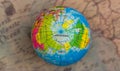 Multicolored globe against the background of the world map, top view,