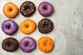 nine halloween donuts on a table with wood texture tiled with Copy space