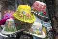 Multicolored handmade women`s hats made of felt with decorations and embroidery are sold in the shop