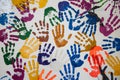 Multicolored handprints scattered across a white surface, reflecting creativity and community