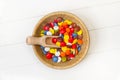 Multicolored hard shell chocolate candies in a wooden bowl