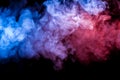 Multicolored heavy smoke from a vape of blue and purple color of the exhaled by scattered by clubs on a black isolated background Royalty Free Stock Photo