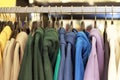 Multicolored hoodies on hangers in a sports store close-up, clothing concept