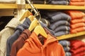 Multicolored hoodies on hangers in a sports store close-up, clothing concept