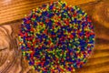 Multicolored hydrogel balls in a glass bowl on wooden table. Top view Royalty Free Stock Photo