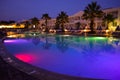 Multicolored illuminated swimming pool at hotel resort in Greece , Corfu during night .