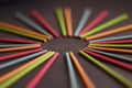 Multicolored Indian incense sticks lie in the shape of sun and rays on a brown background, with empty circle, side view Royalty Free Stock Photo