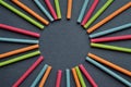 Multicolored Indian incense sticks lie in the shape of sun and rays on a dark gray background, with empty circle Royalty Free Stock Photo