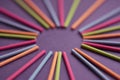 Multicolored Indian incense sticks lie in the shape of sun and rays on a dark purple background, with empty circle Royalty Free Stock Photo