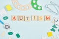 Multicolored inscription autism on wooden squares, stethoscope, educational toys on a blue background, autism diagnosis concept Royalty Free Stock Photo