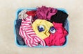 Multicolored laundry in a basket and capsules for washing on a beige background Royalty Free Stock Photo